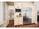 Well-organized pantry with custom shelving, stainless steel refrigerator, microwave, and countertop space at 13106 Bien Ct, Huntersville, NC 28078
