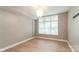 Sunlit bedroom featuring hardwood floors and a modern light fixture; window overlooking the community at 1320 Fillmore Ave # 112, Charlotte, NC 28203
