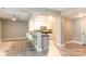 Open-concept living room with light wood floors, bar seating, and a view into the modern kitchen at 1320 Fillmore Ave # 112, Charlotte, NC 28203