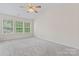 A spacious bedroom with vaulted ceilings, natural light from the three windows, and a ceiling fan at 15009 Medlock Ln, Charlotte, NC 28277