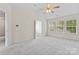 A spacious bedroom with a view into a bathroom with tub and shower, natural light, and a ceiling fan at 15009 Medlock Ln, Charlotte, NC 28277