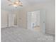A spacious bedroom with a view into the bathroom with vanity and sink area, and a ceiling fan at 15009 Medlock Ln, Charlotte, NC 28277