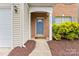 Close-up of front entrance with blue door, brick facade, and green shrubbery at 15009 Medlock Ln, Charlotte, NC 28277