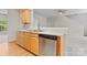 Kitchen featuring stainless steel dishwasher, light wooden cabinets, and view to stairs at 15009 Medlock Ln, Charlotte, NC 28277