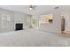 Living room with neutral carpet, fireplace, and an open view of the kitchen at 15009 Medlock Ln, Charlotte, NC 28277