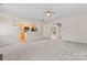 Spacious living room flowing into the kitchen, complete with neutral paint and carpeted floors at 15009 Medlock Ln, Charlotte, NC 28277