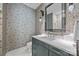 Bathroom featuring wallpaper, vanity with white countertop, and a glass enclosed shower with marble tile at 1550 High St, Charlotte, NC 28211