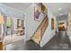 A bright hallway with staircase, elegant artwork, and dark hardwood floors leading to a dining area at 1550 High St, Charlotte, NC 28211
