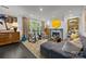 Bright living room featuring a fireplace, plush sofa, art, and access to the outdoors through french doors at 1550 High St, Charlotte, NC 28211