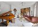 Stylish living room featuring a grand piano, eclectic art, and plush seating area, exuding sophistication at 1550 High St, Charlotte, NC 28211