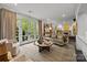 Living room with neutral decor, french doors that leads to a green, tree-lined patio, and inviting furniture at 1550 High St, Charlotte, NC 28211