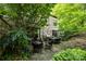 A private outdoor patio with stone flooring, surrounded by lush greenery, and cozy seating arrangements at 1550 High St, Charlotte, NC 28211