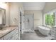 Bright bathroom with modern fixtures, soaking tub, glass shower and dual vanities at 156 Clear Springs Rd, Mooresville, NC 28115