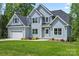 Charming two-story home with a manicured lawn, attached garage, and a combination of vertical and shingle siding at 156 Clear Springs Rd, Mooresville, NC 28115
