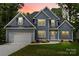 Charming two-story home with a manicured lawn, attached garage, and a combination of vertical and shingle siding at 156 Clear Springs Rd, Mooresville, NC 28115