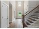 Bright foyer featuring hardwood floors, a staircase with wrought iron railings, and a high ceiling with a modern chandelier at 156 Clear Springs Rd, Mooresville, NC 28115