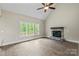 Living room features hardwood floors, vaulted ceiling with a fan and stone fireplace, plus multiple view windows at 156 Clear Springs Rd, Mooresville, NC 28115