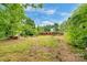 Landscaped backyard featuring a fire pit and plenty of green space at 1713 Wildwood Dr, Albemarle, NC 28001