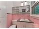 Pink bathroom features tile walls, a vanity with sink, and a built-in shelf at 1713 Wildwood Dr, Albemarle, NC 28001