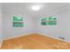 Bright bedroom with two windows and light-colored wood floors at 1713 Wildwood Dr, Albemarle, NC 28001