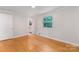 Bright bedroom features hardwood floors, a window, closet, and light gray walls at 1713 Wildwood Dr, Albemarle, NC 28001