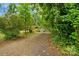 Gravel driveway leading to a brick home surrounded by mature landscaping at 1713 Wildwood Dr, Albemarle, NC 28001