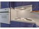 Stove with white range and white oven sits atop navy blue cabinetry at 1713 Wildwood Dr, Albemarle, NC 28001