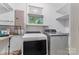 Laundry room with white washer, gray dryer, and a small window at 1713 Wildwood Dr, Albemarle, NC 28001