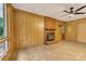 Living room features wood paneling, brick fireplace, and window with wooded outdoor views at 1713 Wildwood Dr, Albemarle, NC 28001
