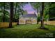 Back exterior view of a white home with fenced yard, mature trees, and well-manicured lawn at 1807 Arnold Dr, Charlotte, NC 28205