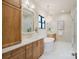 Bright bathroom featuring dual sinks, marble countertop, a freestanding tub, and frameless glass shower, providing luxury at 1807 Arnold Dr, Charlotte, NC 28205