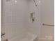 Bright bathroom featuring shower and tub with white tile, built-in shelves and matte silver fixtures at 1807 Arnold Dr, Charlotte, NC 28205