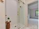 Beautiful bathroom featuring glass shower, white tile, and gold fixtures, next to a bedroom at 1807 Arnold Dr, Charlotte, NC 28205