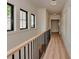 Bright hallway features wood floors, black metal railing, natural light, and decorative white wall panels at 1807 Arnold Dr, Charlotte, NC 28205