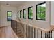 Bright hallway with wood floors, black metal railings, and abundant natural light from large windows at 1807 Arnold Dr, Charlotte, NC 28205
