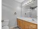 Bathroom with tile flooring, a wood vanity, white toilet, and a bathtub with shower at 2008 Taras Trace Dr, Statesville, NC 28625