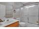 Bright bathroom features a shower-tub combo with glass doors and neutral wallpaper at 2008 Taras Trace Dr, Statesville, NC 28625