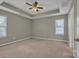 Spacious bedroom featuring neutral walls, plush carpeting, a ceiling fan, and natural light from a window at 2008 Taras Trace Dr, Statesville, NC 28625