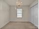 Bedroom with neutral walls, plush carpeting, a chandelier, a window, and a closet at 2008 Taras Trace Dr, Statesville, NC 28625
