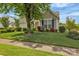 Landscaped front yard view of home featuring mature tree, lush green grass, and blue window shutters at 2008 Taras Trace Dr, Statesville, NC 28625