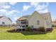 A spacious backyard featuring a well-maintained lawn, mature landscaping, and a screened in back porch at 206 Summey Barker Dr, Dallas, NC 28034