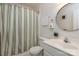 Bathroom showcases a toilet, shower with striped curtain, and a vanity with a round mirror at 206 Summey Barker Dr, Dallas, NC 28034