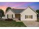 Charming home with neutral siding, manicured landscaping, black shutters, and a brick front porch at 206 Summey Barker Dr, Dallas, NC 28034