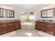 Elegant bathroom featuring a soaking tub, dual vanities, granite countertops, and large windows at 209 Helton Ln, Fort Mill, SC 29708