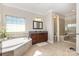 Bright bathroom features a soaking tub, walk-in shower with seating, and granite-topped vanity at 209 Helton Ln, Fort Mill, SC 29708