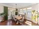 Sunny dining room with rustic wood table, chandelier, hardwood floors, large windows and green curtains at 209 Helton Ln, Fort Mill, SC 29708