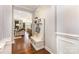 Hallway with hardwood floors, a coat rack and bench, leading into a cozy living area and modern kitchen at 209 Helton Ln, Fort Mill, SC 29708