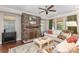 Inviting living room featuring a stone fireplace, a plush sofa, and natural light from large windows at 209 Helton Ln, Fort Mill, SC 29708