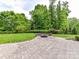 Manicured backyard featuring a stone fire pit, landscaping, and plenty of green space at 2369 Baxter Se Pl, Concord, NC 28025
