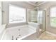 Bathroom features a large soaking tub with a shower, as well as bright windows for natural light at 2369 Baxter Se Pl, Concord, NC 28025